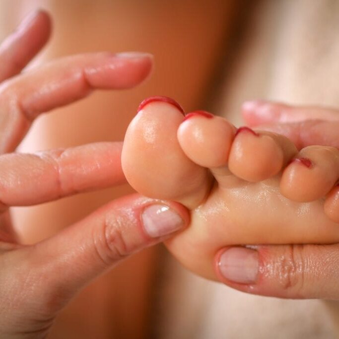 Massage therapist massaging legs of pregnant woman